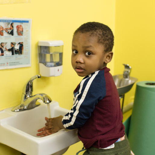 Child washes hands in classroom