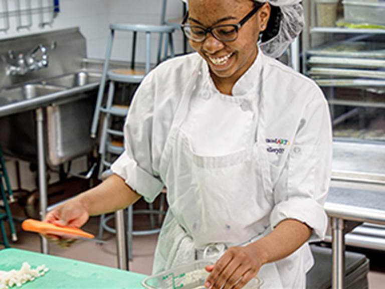 Student cutting up a carrot