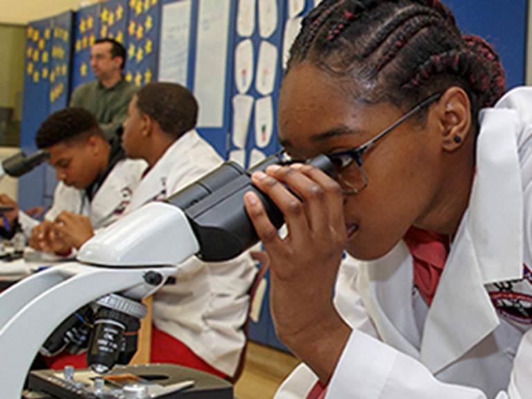 Student looking through a microscope