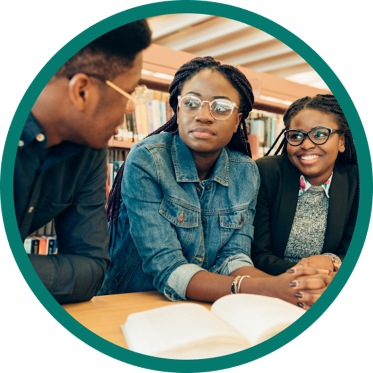 Three students talking in a library