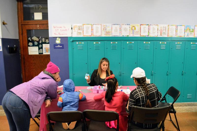 teacher and kids gathered around a table in a school setting