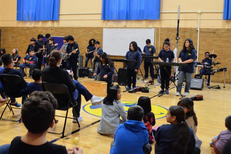 Group of children sitting in a gym at an Elementary School