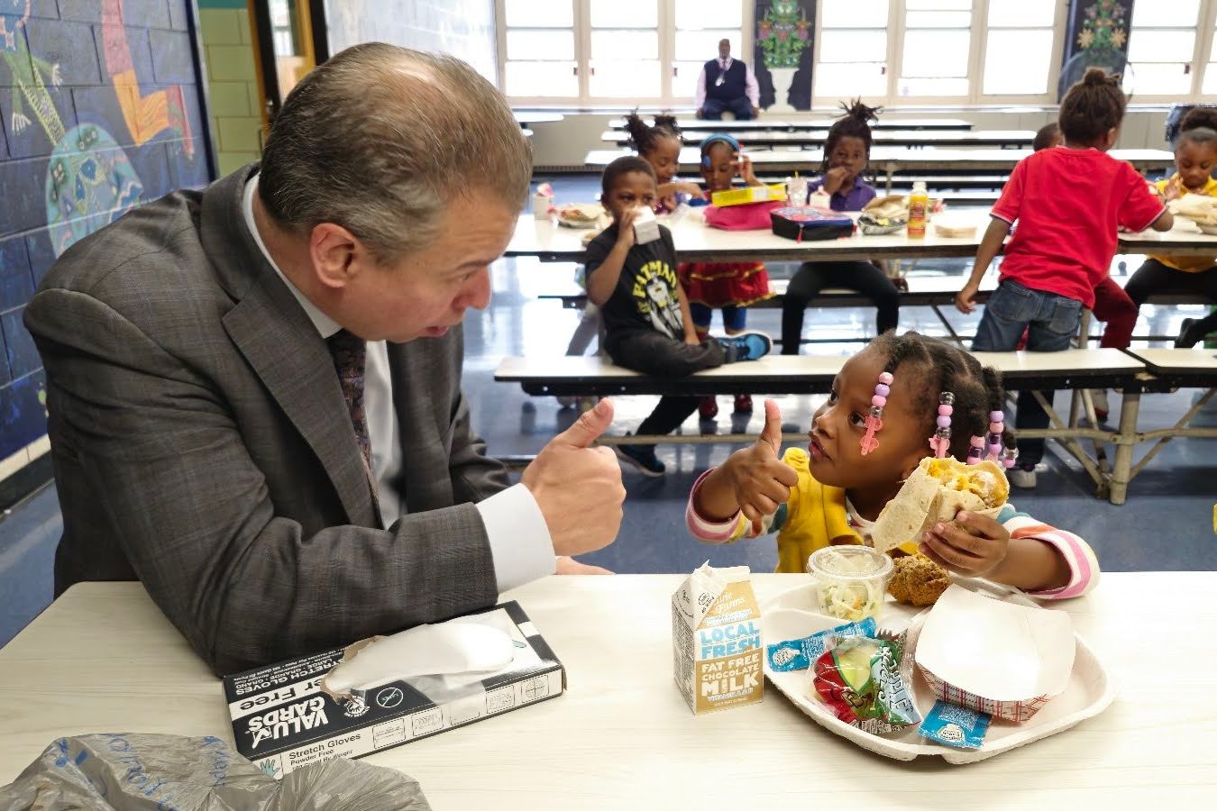 Pedro Martinez asking a young student about their lunch, and receiving a thumbs up.