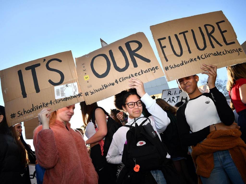 students holding signs that read it's our future