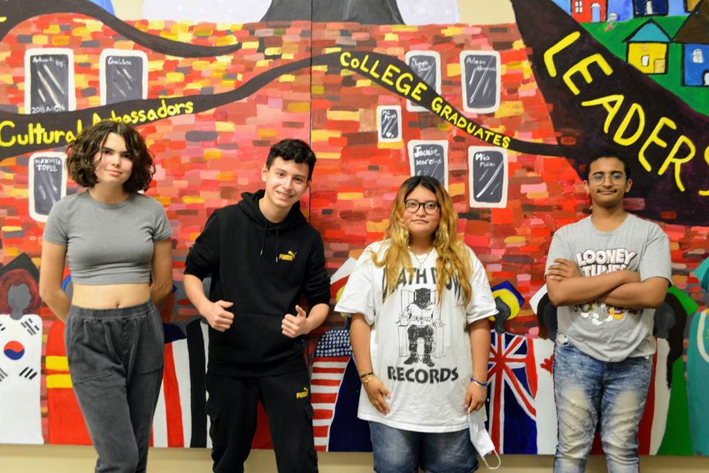 A photo of Peterson students in front of a mural in their school