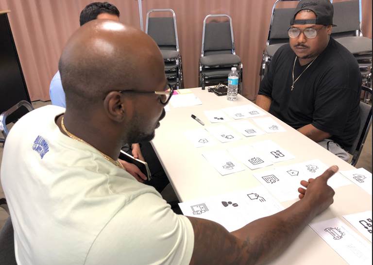 image of men around a table viewing notes