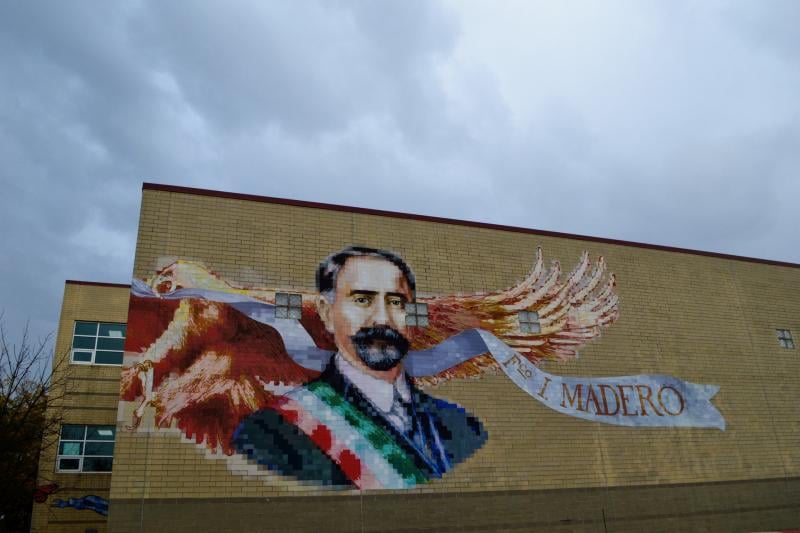 a mural of a man with a banner on a brick building