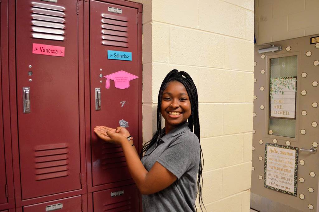 Saharia standing in front of her locker