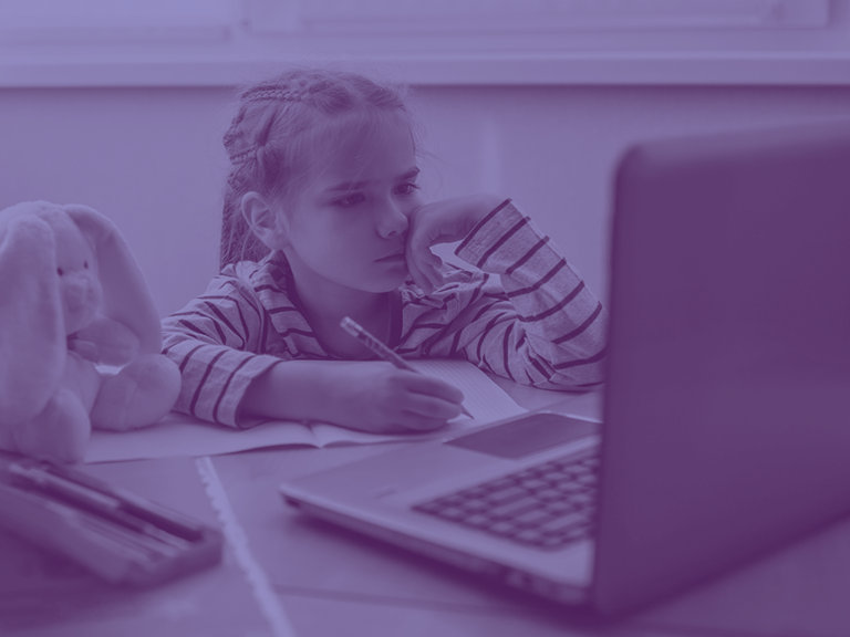 Young student taking notes while watching an online class