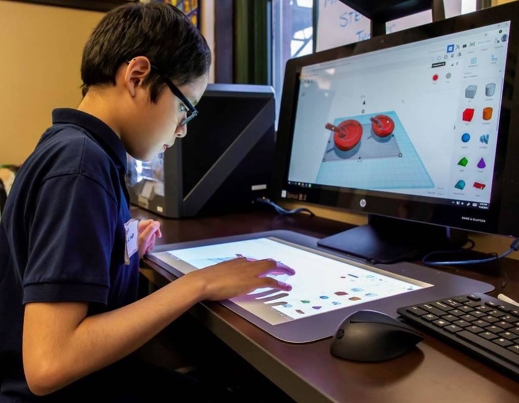 image of student sitting by computer screens