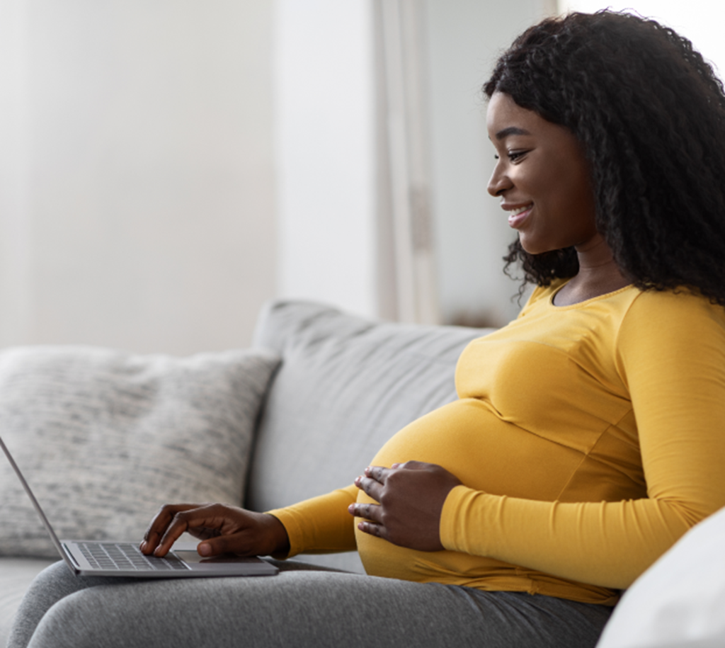 Pregnant mother explores Chicago Early Learning Doula Programs on her laptop