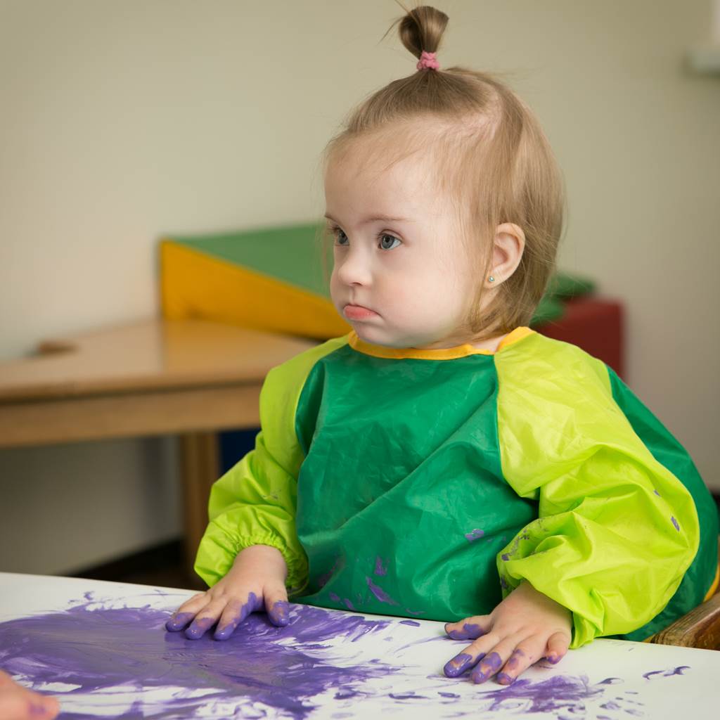 Child in an Individualized Education Program paints in classroom