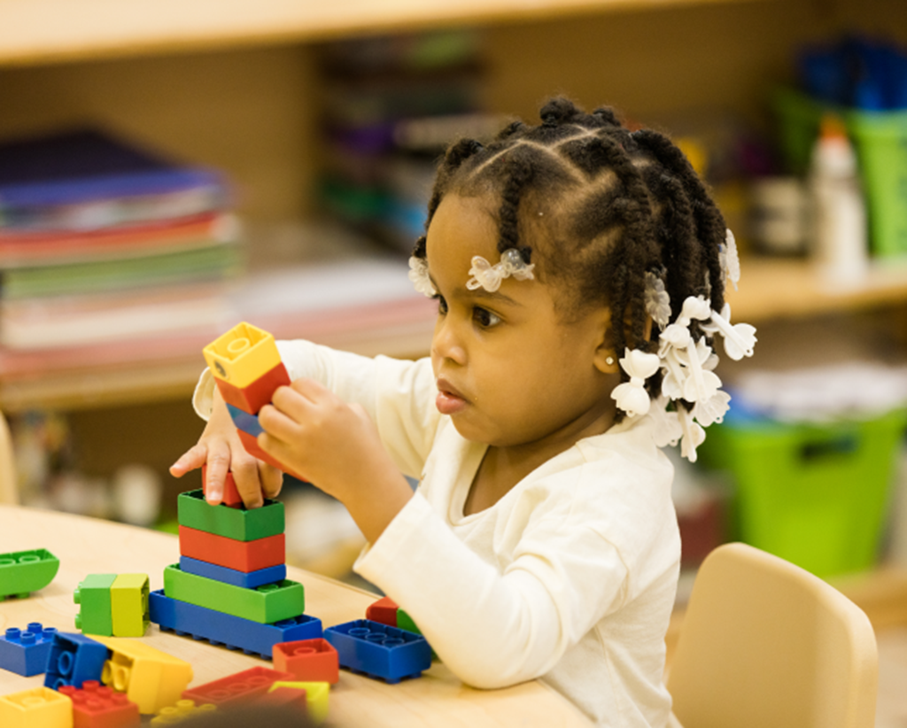Preschooler plays with blocks in classroom