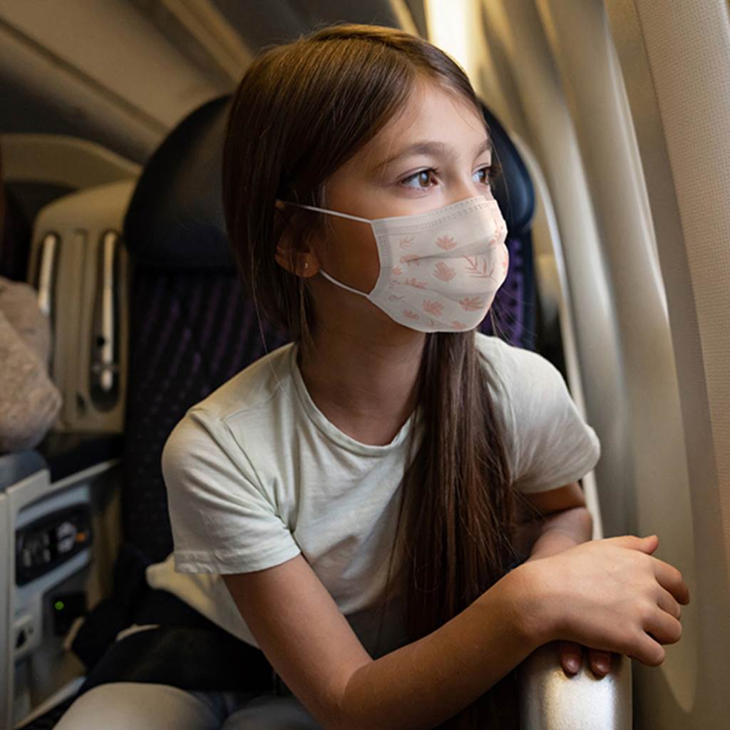 A girls looks out of an airplane window