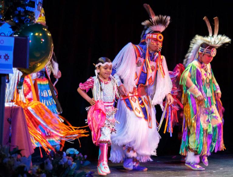 American Indian Education Program's Achievement Celebration, with three dancers wearing traditional clothing