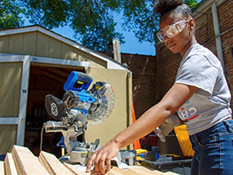 Student working on cutting wood to various sizes