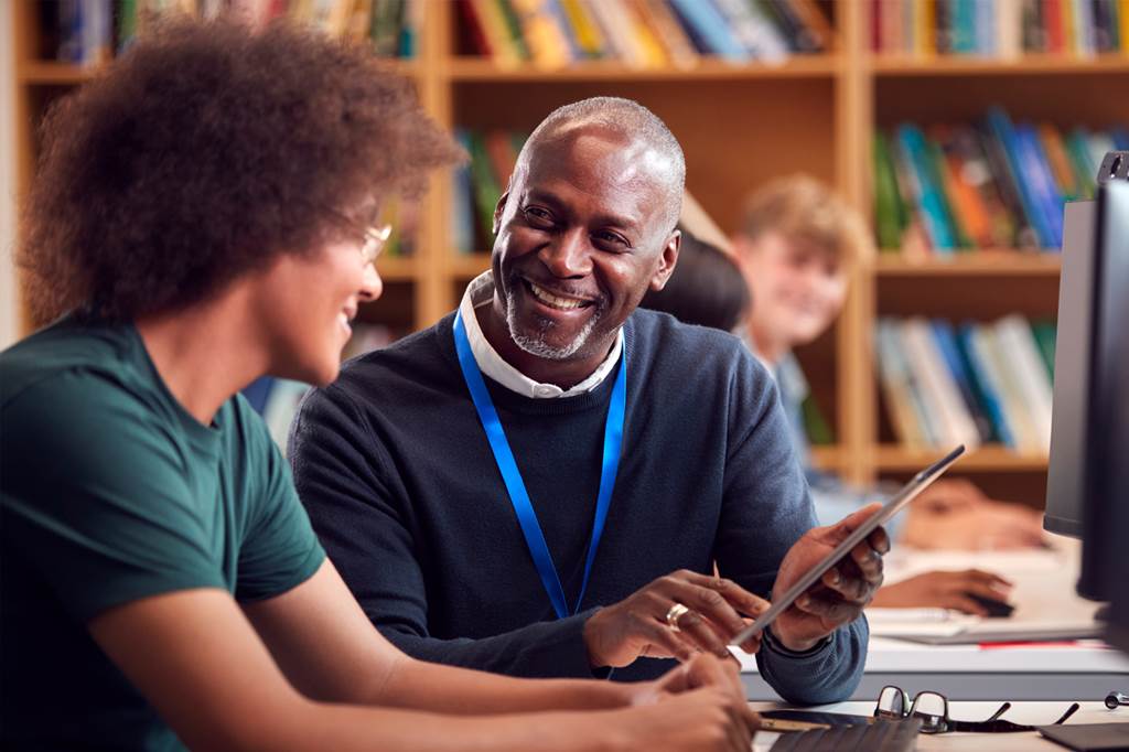 Teacher helping a student study in a library