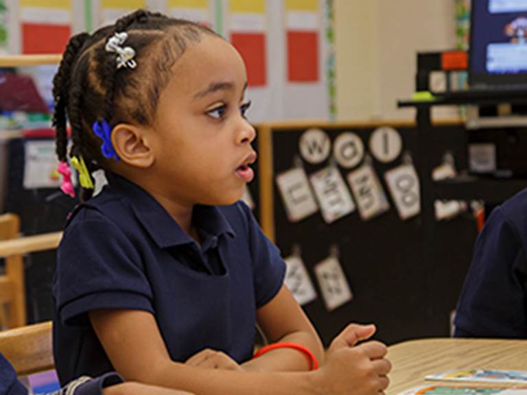 Young child looking eagerly at something in the classroom