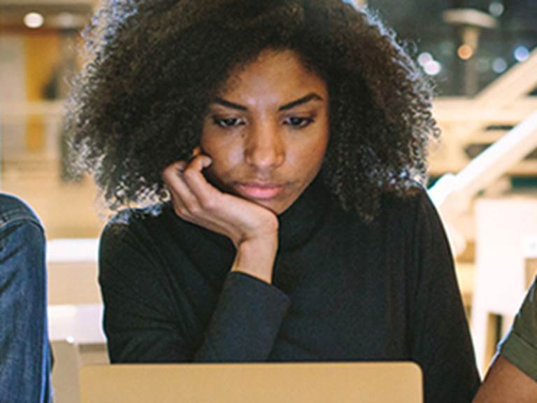 Female college student looking down at a laptop