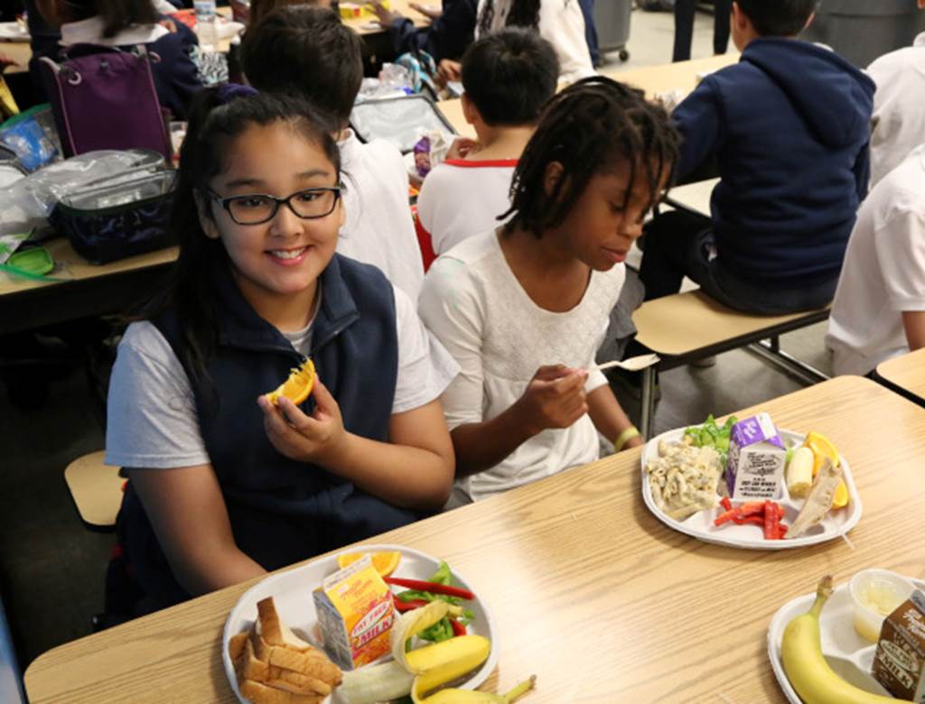 Students eating their lunches within a cafeteria