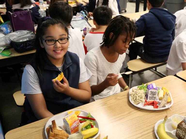 Students eating their lunches within a cafeteria
