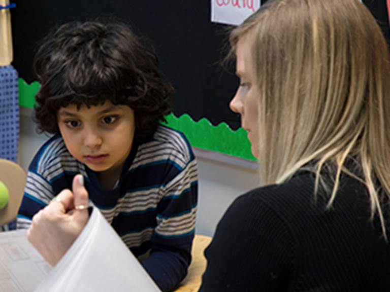 Teacher teaching a student to read