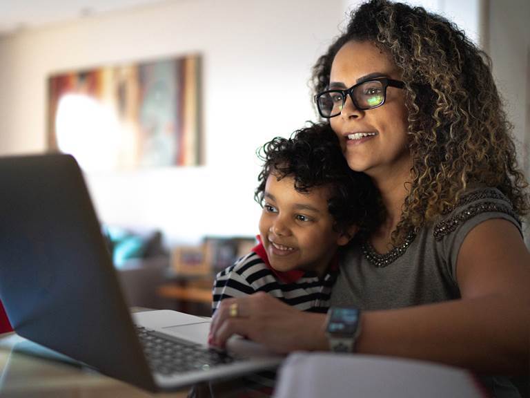A parent and student sit at a computer together