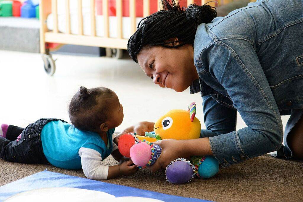 Woman playing on the floor with infant