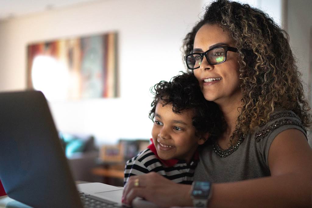 Parent and child watching a webinar on a laptop