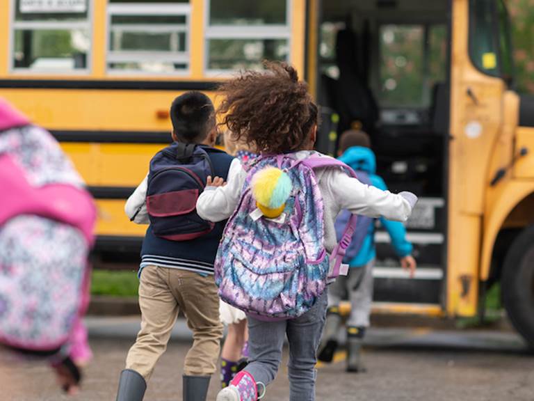 Children get on a school bus