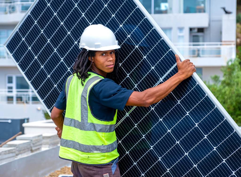 worker carrying a solar panel