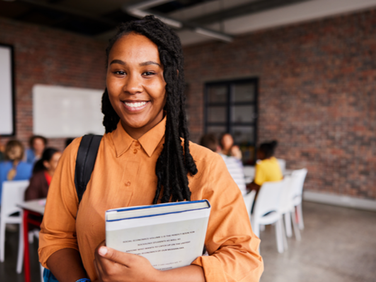 image smiling student holding book