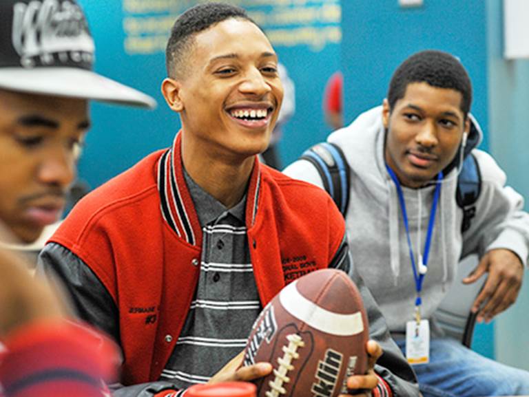 A CPS student holds a football 