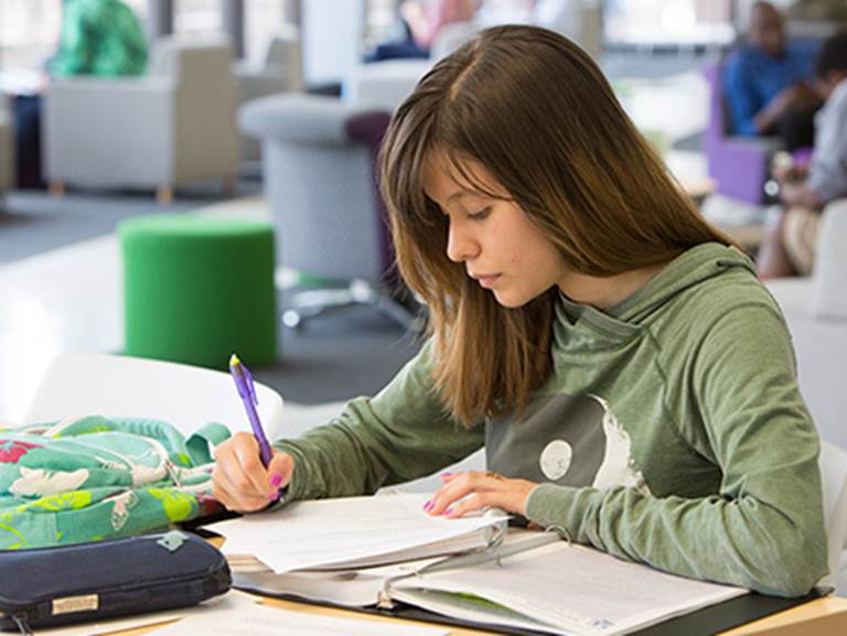 A CPS student works at a desk