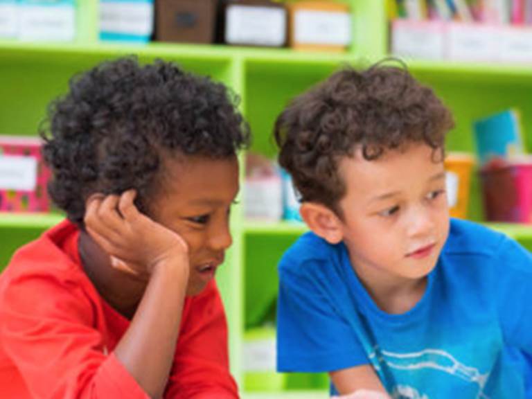 Two elementary students looking at something on a table