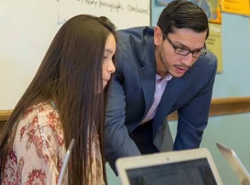 Student and Teacher Looking at Laptop