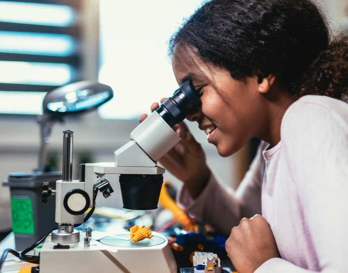 image of student looking into microscope