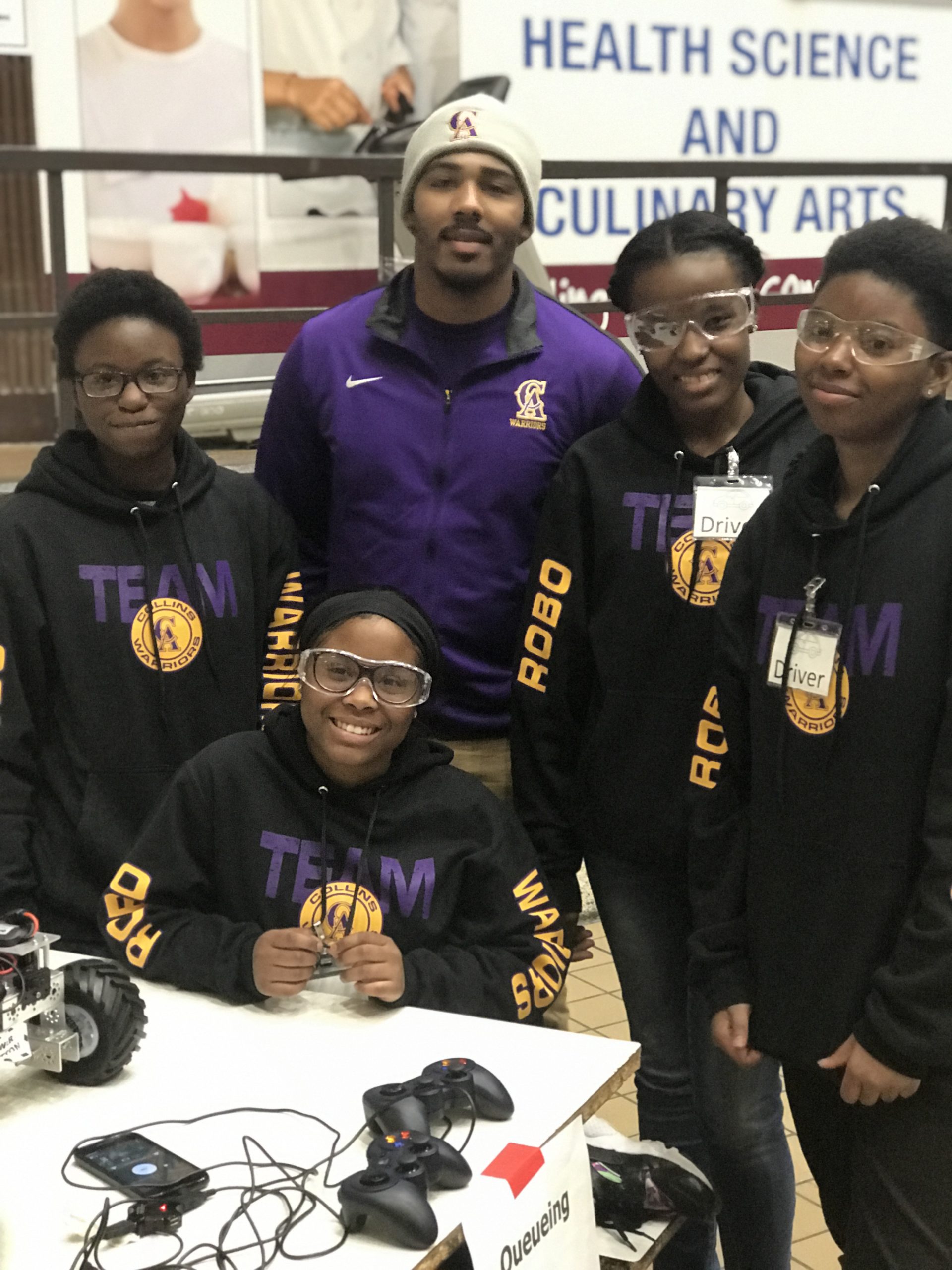 Four female students standing with their coach