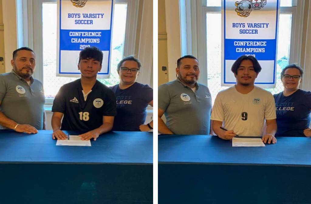 Students signing scholarship papers