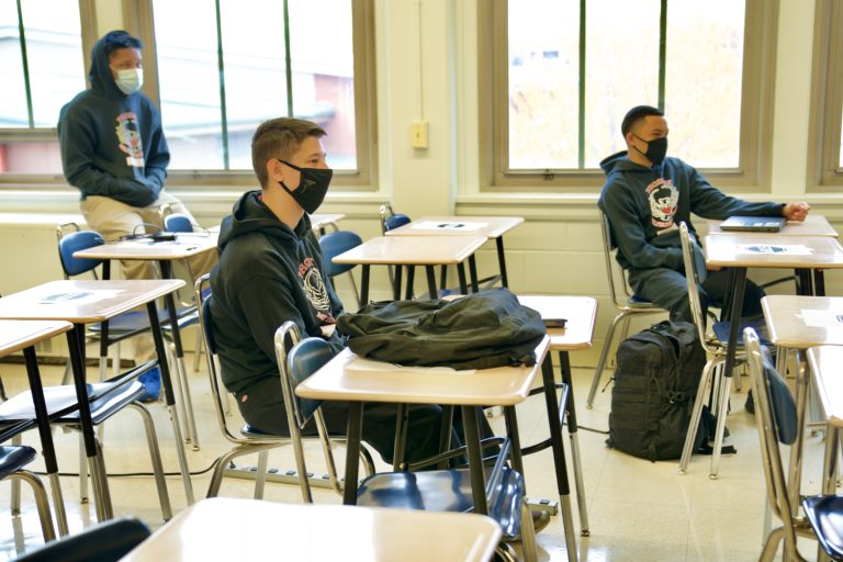 Masked students sitting down