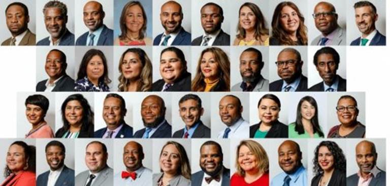 A composite grid of professional headshots showing a large and diverse team of smiling men and women.
